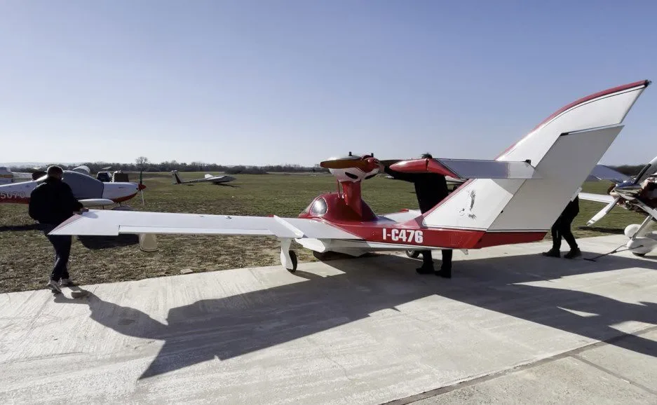 Osprey 2 aircraft with red and white paint scheme on the ground.