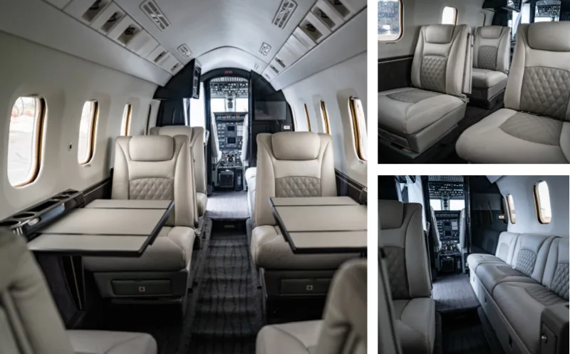 Interior view of the aircraft cabin with leather seats and tables.