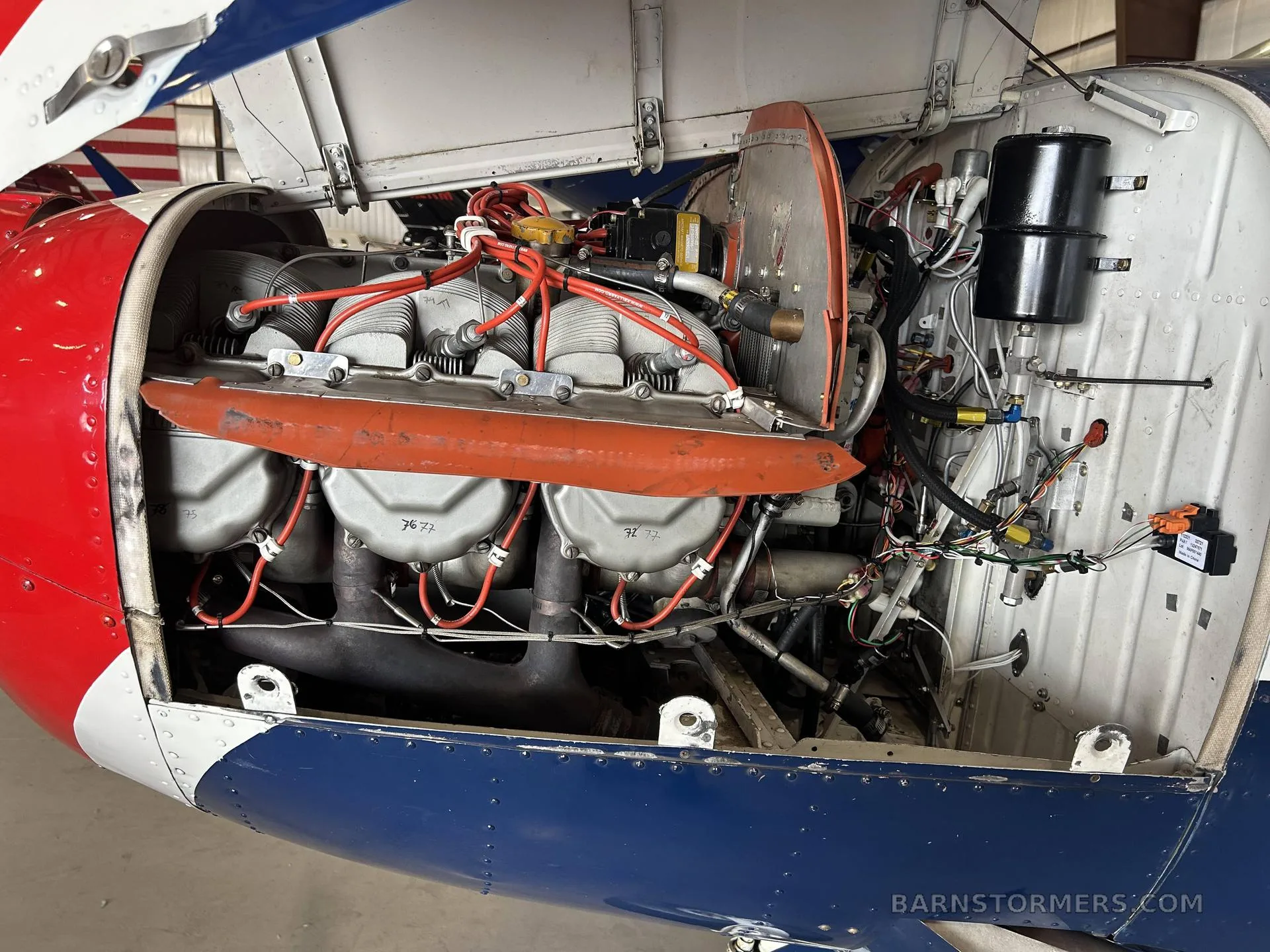 Close-up view of the aircraft's engine compartment with the cowling open, revealing the engine and wiring.