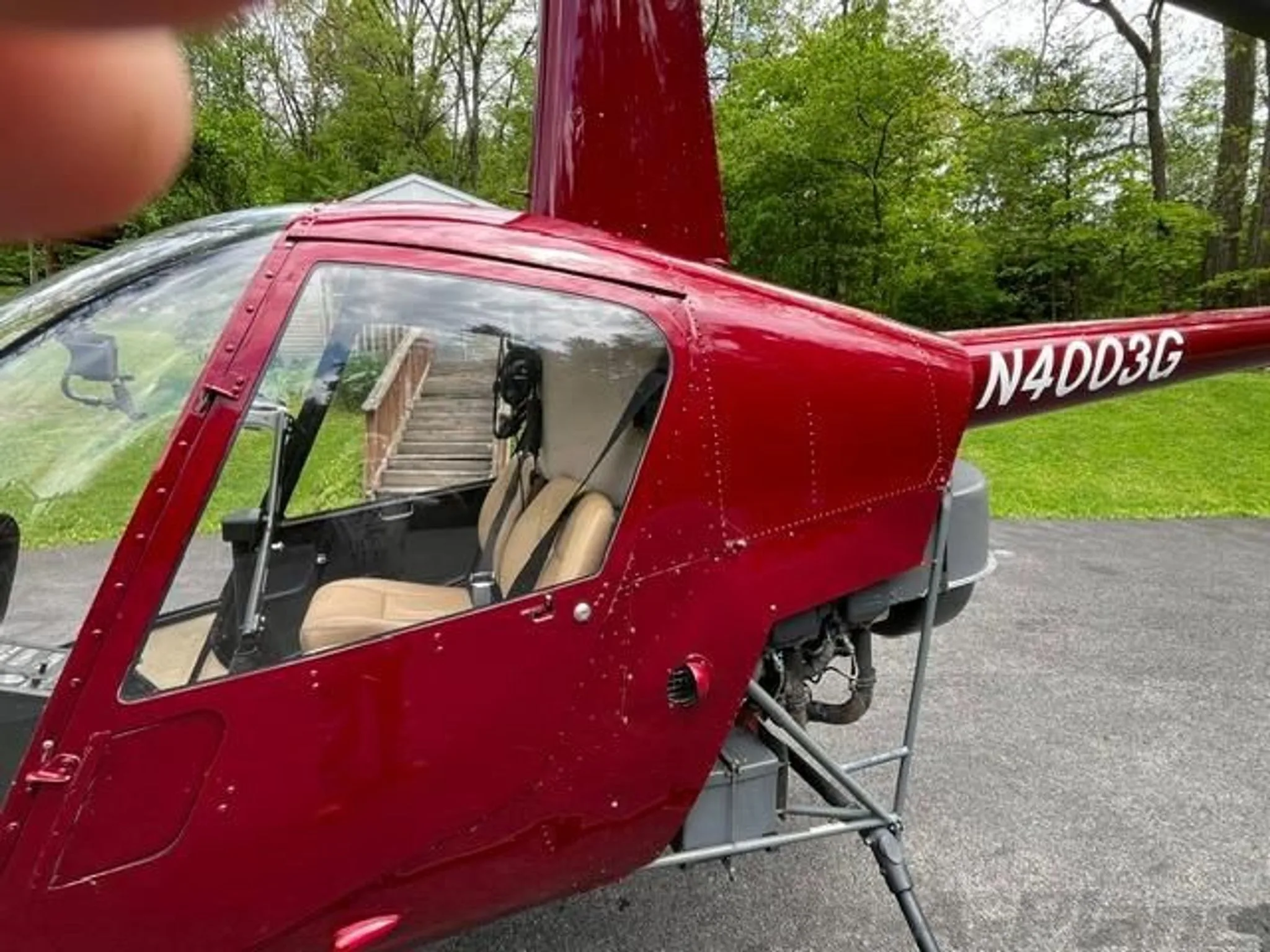 A side view of a red helicopter with registration N4003G, parked outdoors.