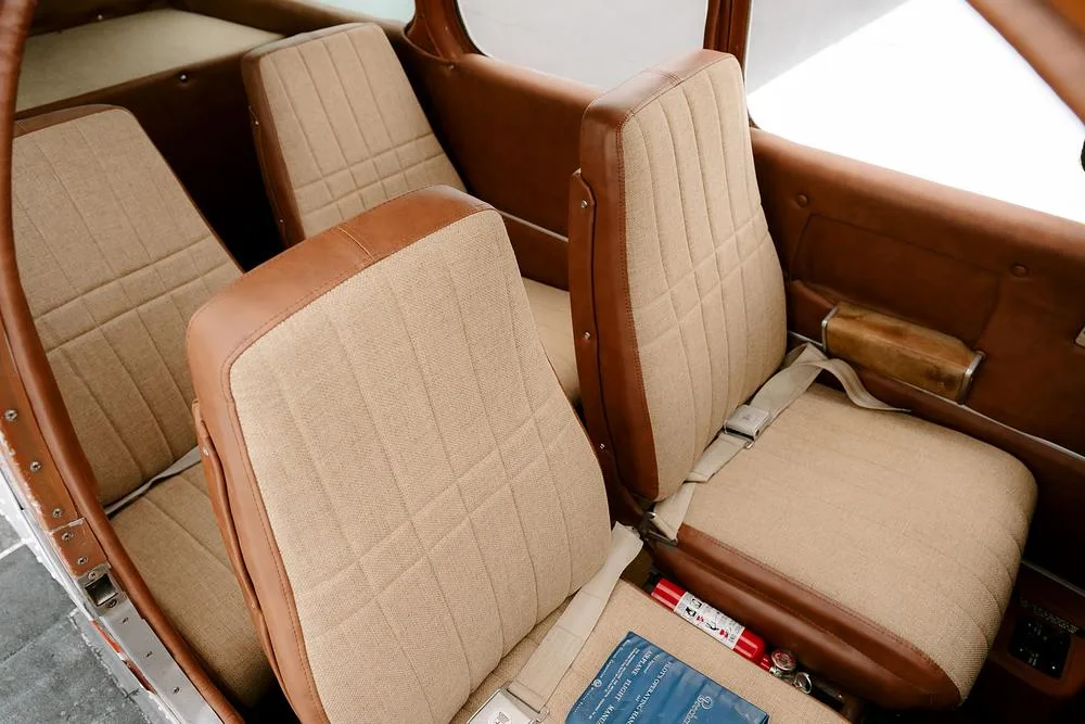 The tan and brown fabric seats in the cabin interior of the aircraft.