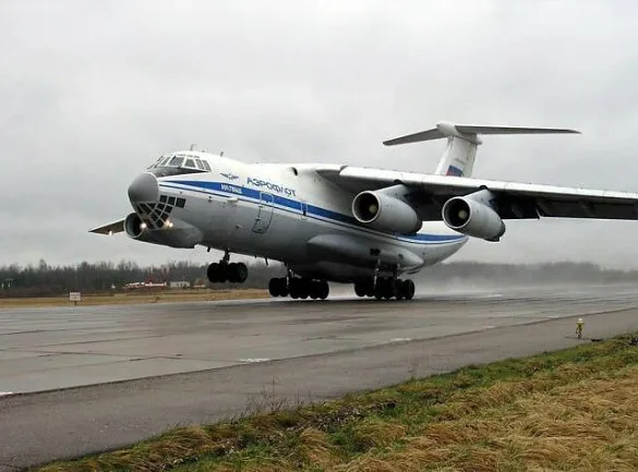 The interior of a large cargo aircraft's hold is visible, showing a loading ramp and internal structural elements.