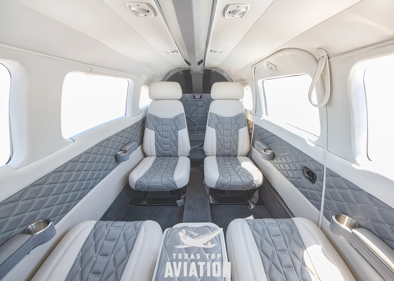 A view of the aircraft's interior cabin with white and grey quilted seats.