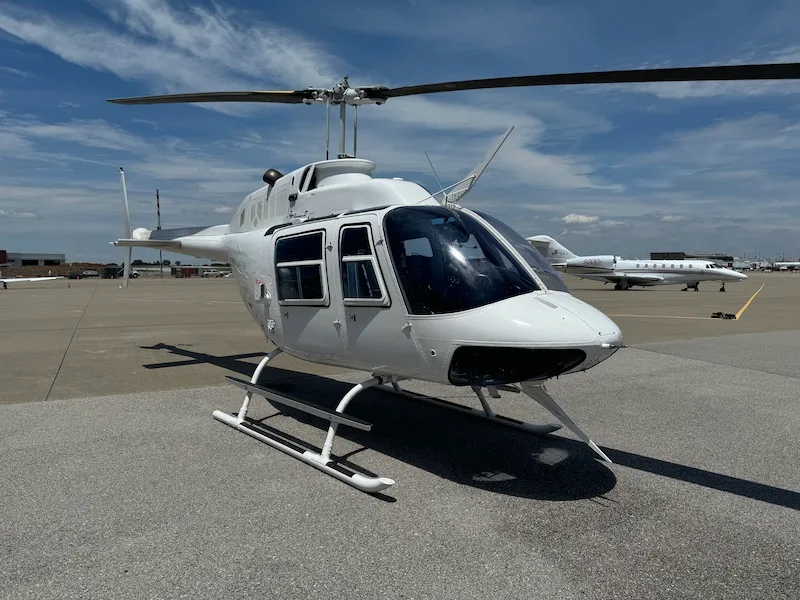 Front view of a white Bell 206L-4 helicopter on the tarmac.