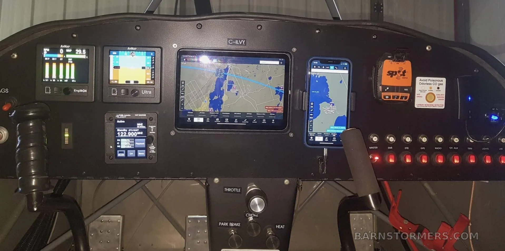 A close-up view of the C-ILVY aircraft's cockpit panel, featuring various digital screens, switches, and flight controls.