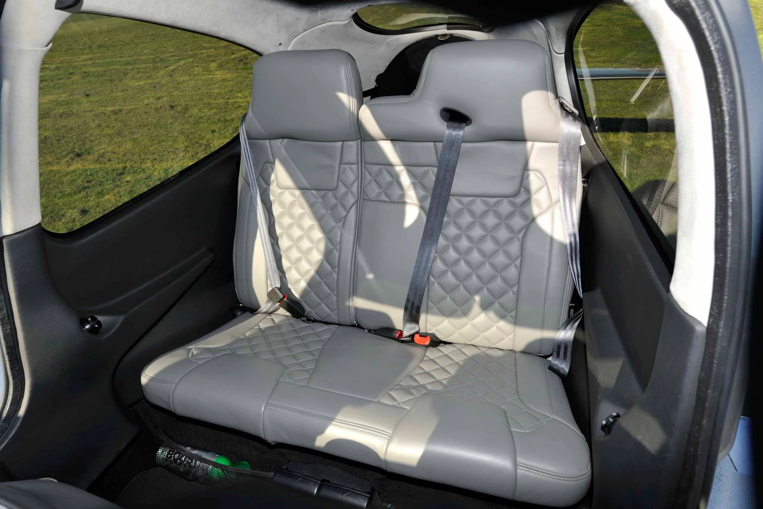 The rear grey quilted leather seats of a Cirrus SR22T cabin.