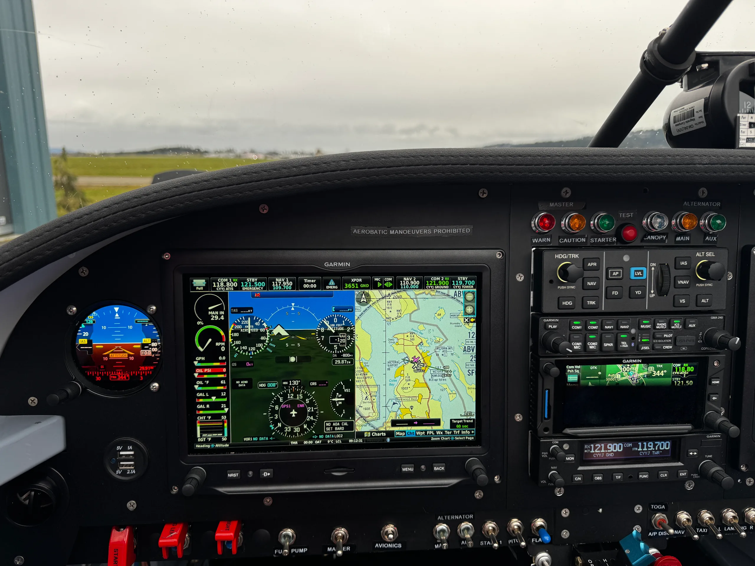 A close-up view of the aircraft's instrument panel, showing a large Garmin display with navigation and flight information, and various controls.