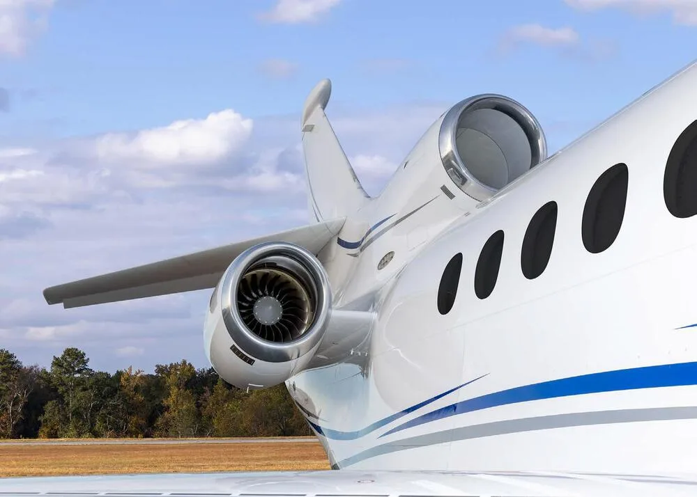 A close-up view of the rear fuselage and engines of a white Dassault Falcon business jet from a different angle.