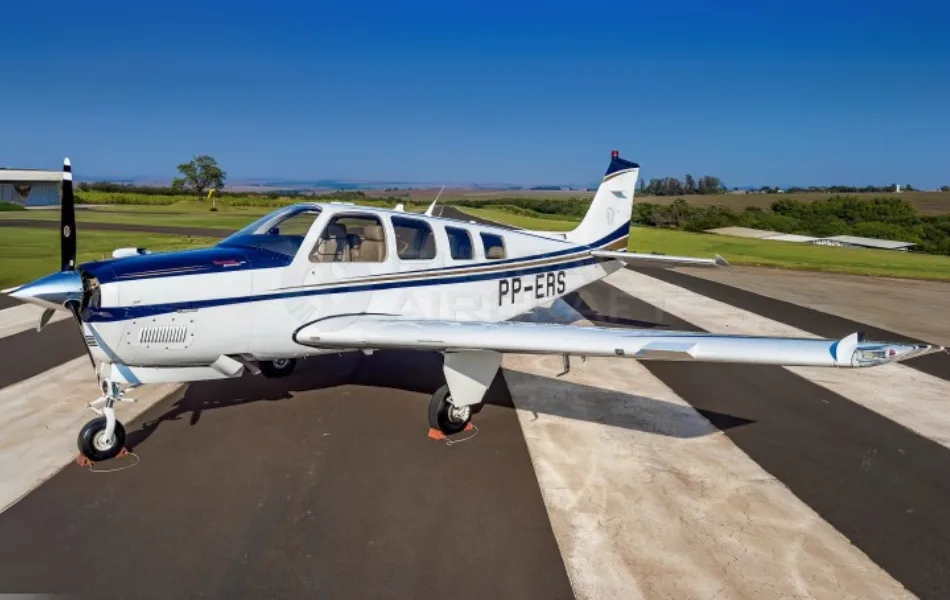 A white and blue single-engine propeller aircraft, registration PP-ERS, parked on a tarmac under a clear blue sky.