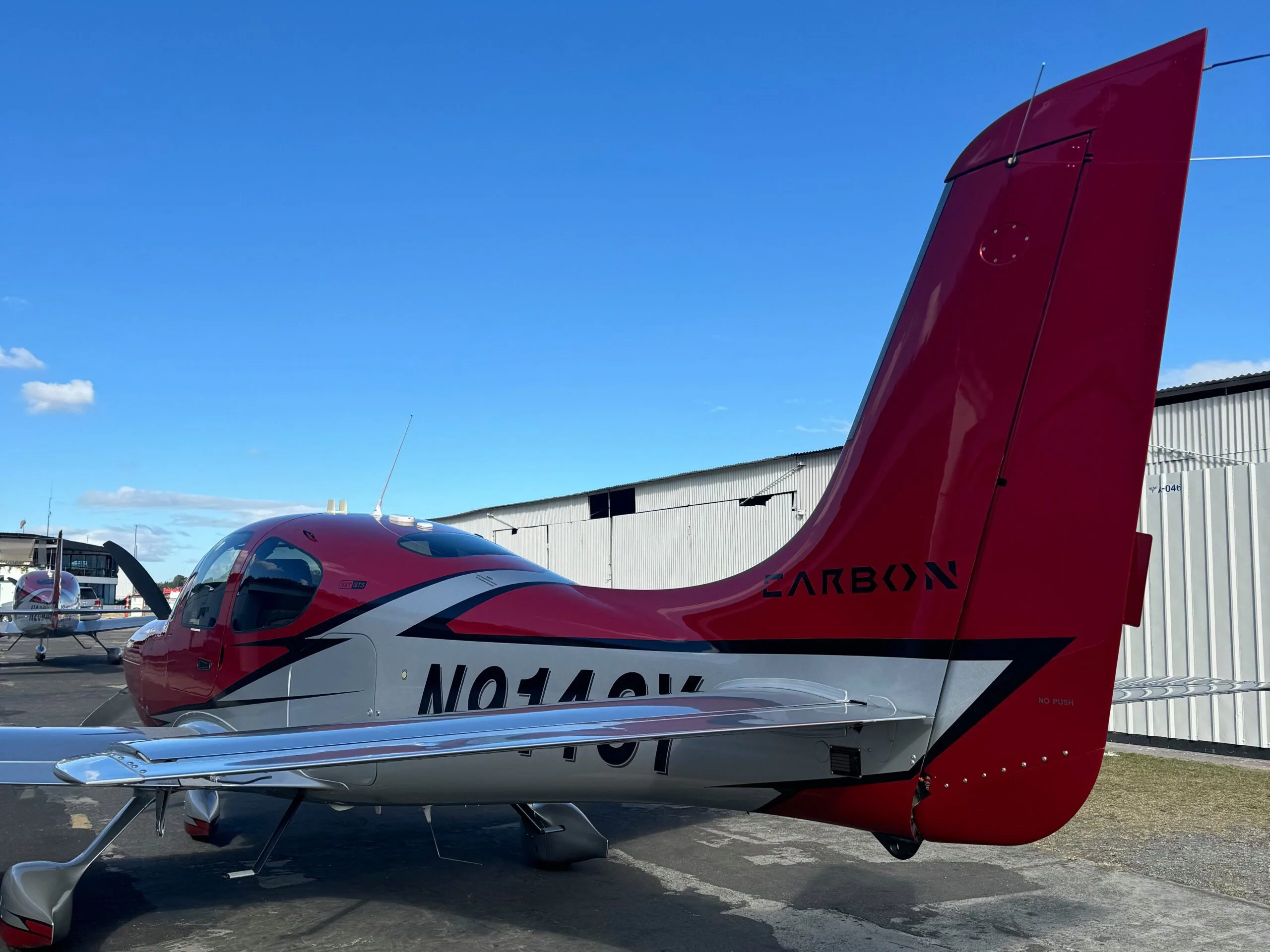 A close-up view of the red and silver tail and rear fuselage of the Cirrus SR22 aircraft N914SY.