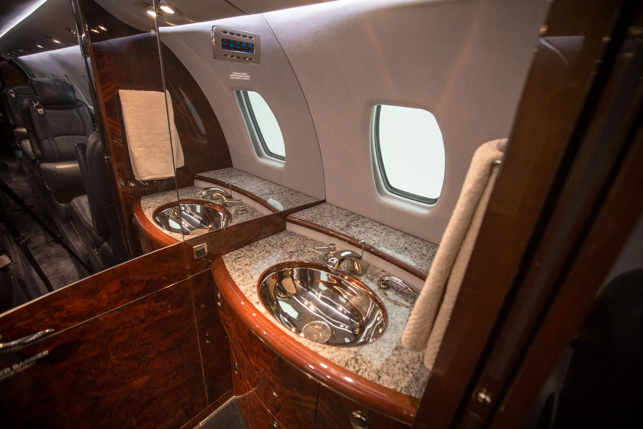 A view of the aircraft lavatory with sinks and mirrors.