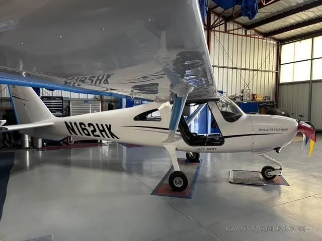 A white Cessna Skycatcher N162HK light-sport aircraft is parked in a hangar.