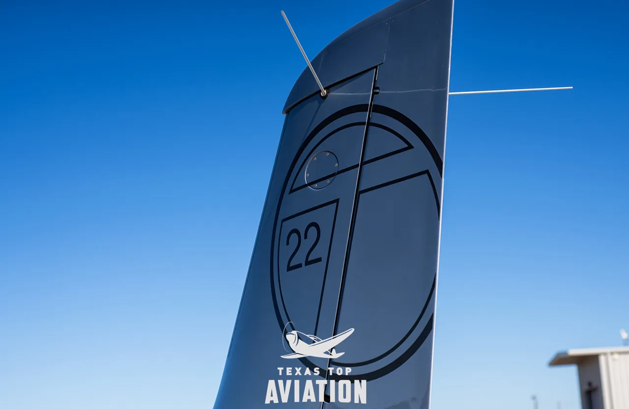 Close-up of the tail of a silver Cirrus SR22 aircraft with a '22' logo.