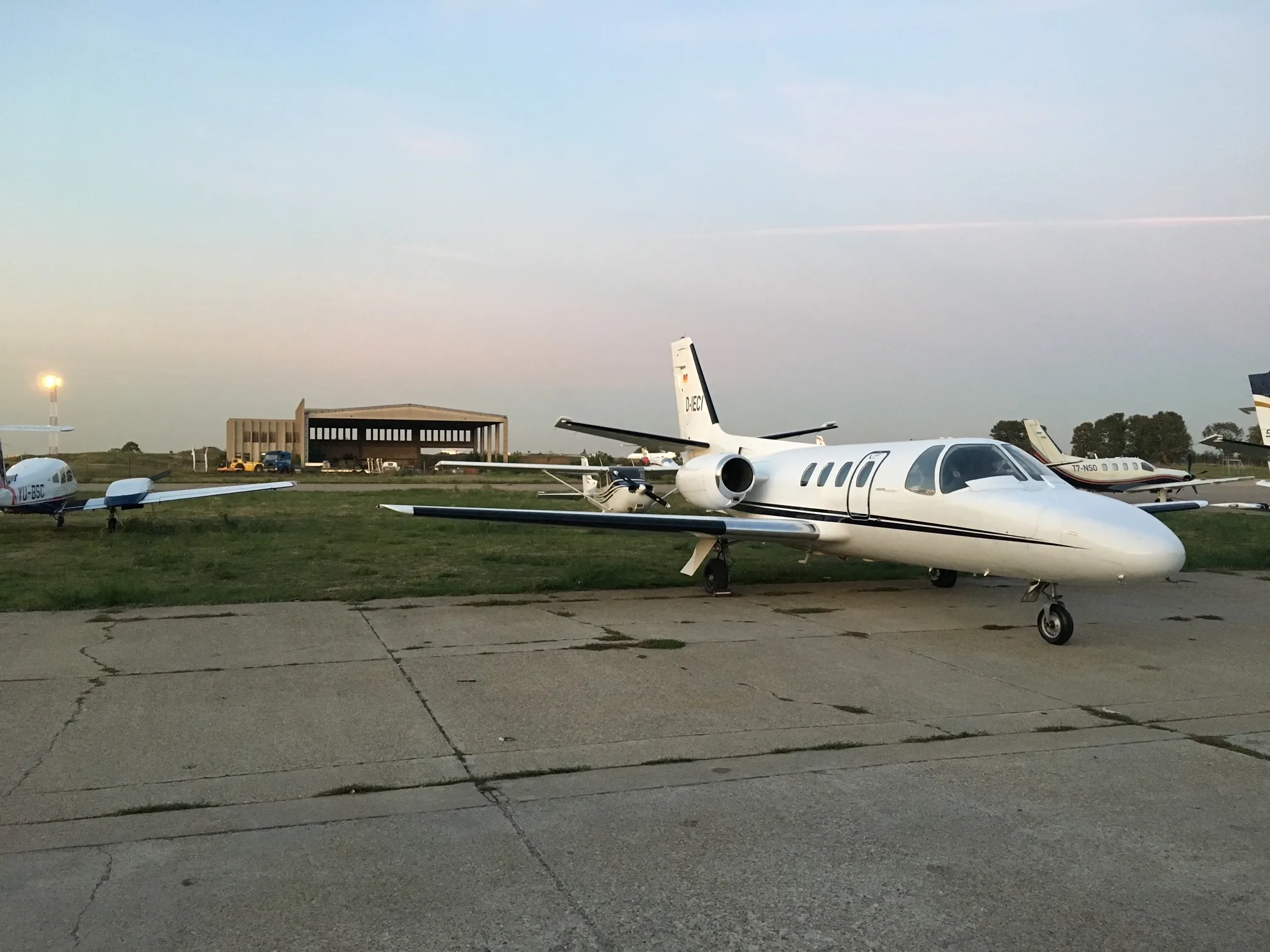 A Cessna Citation Mustang aircraft, registration D-IECI, parked on the tarmac with other aircraft in the background.
