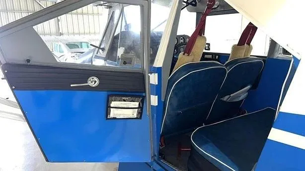 View of the blue interior seats and open door of the aircraft.