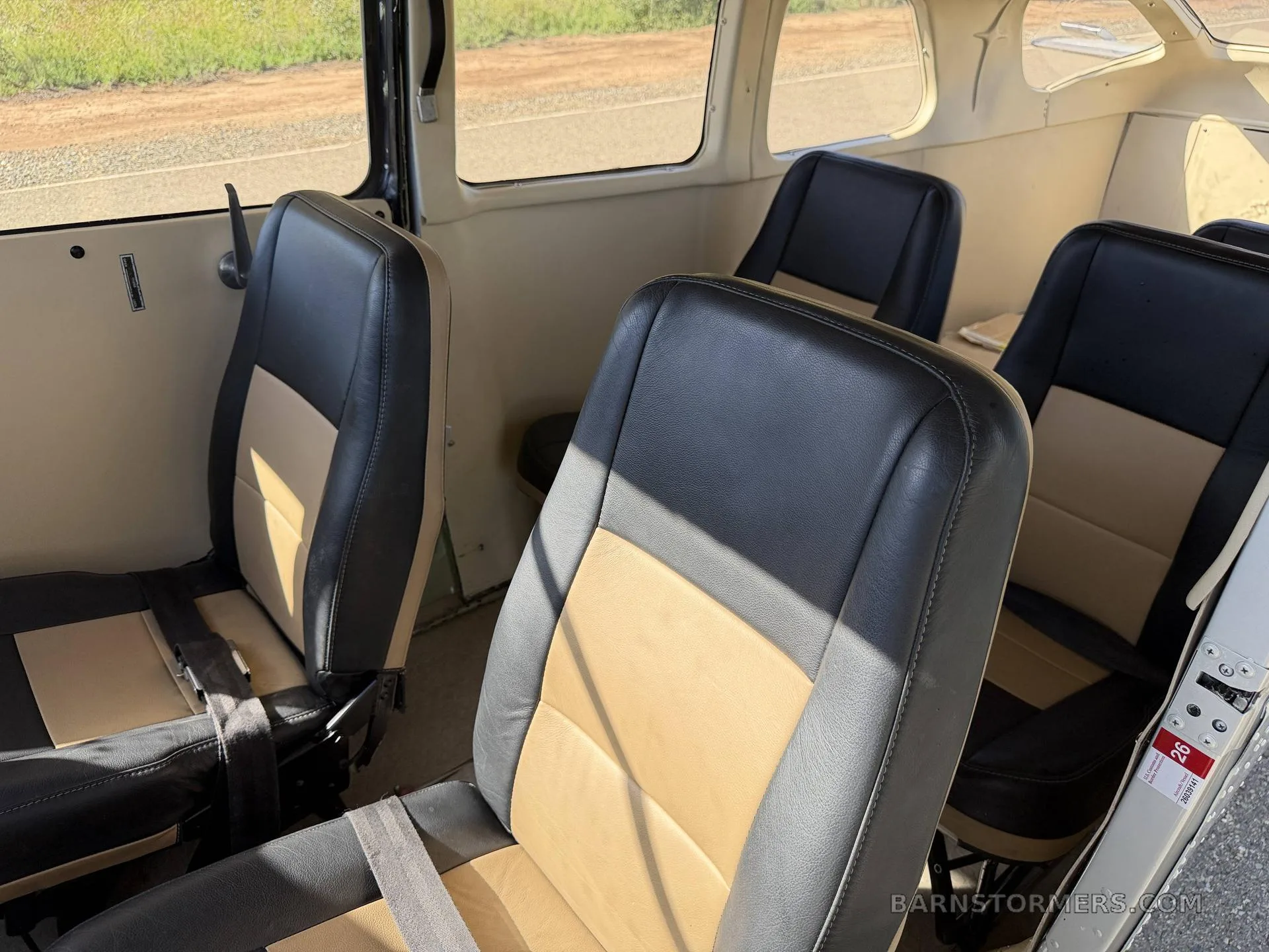 The rear two-tone black and tan seats in the cabin of a Cessna 206GT.
