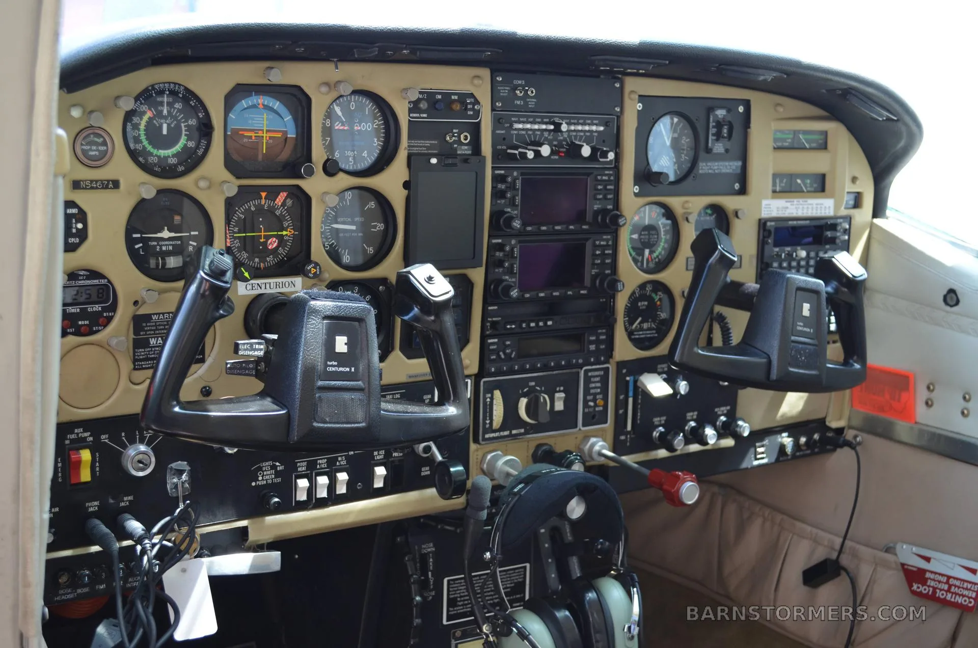 The cockpit instrument panel of a Cessna Centurion II, showing analog gauges, avionics, and two control yokes.