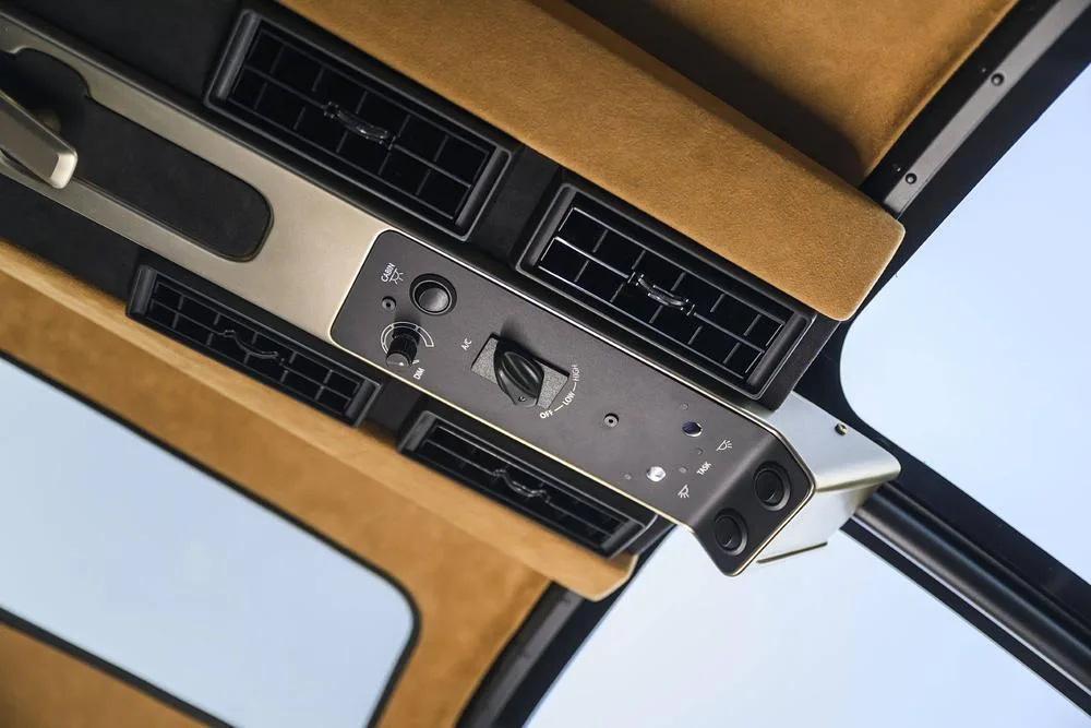 An overhead panel with air vents and environmental controls inside a helicopter cabin.