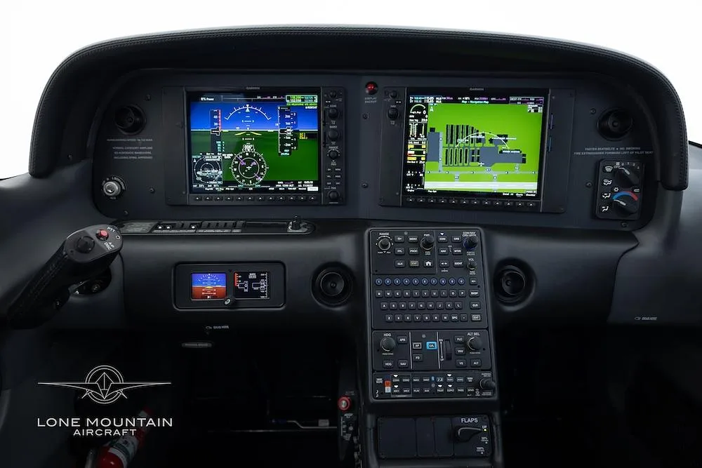 The modern glass cockpit of a Cirrus SR22 aircraft, featuring two large display screens and a control yoke.