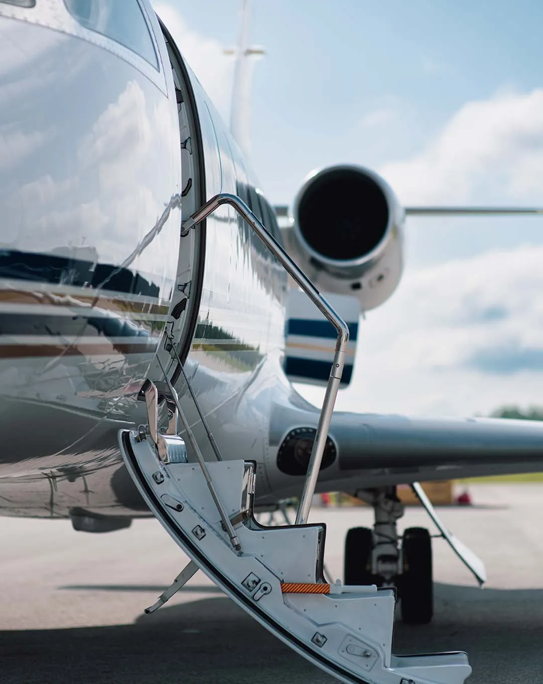 An Embraer Praetor 600 business jet with a grey and dark blue paint scheme flies above the clouds.