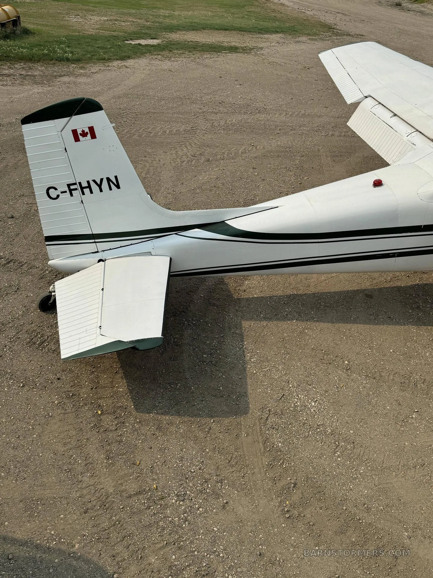 An overhead view of the tail section of a white and green Cessna 180 aircraft with Canadian registration C-FHYN.