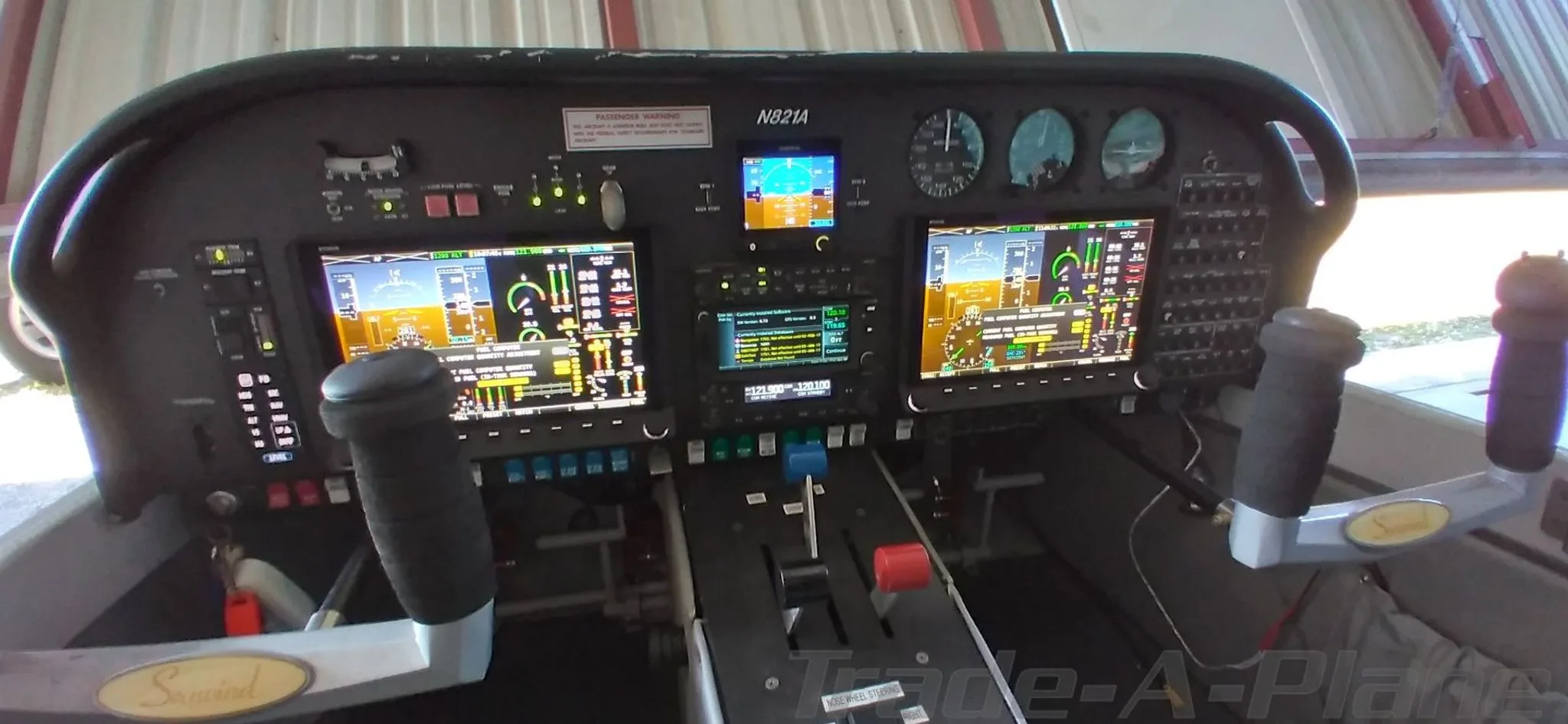 The cockpit of the Searey aircraft, featuring a modern glass panel with multiple digital displays and control sticks.