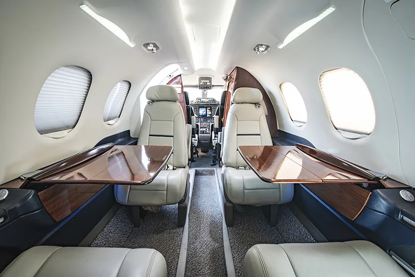 Interior view of the Cirrus Vision Jet cabin with leather seats and wood accents.