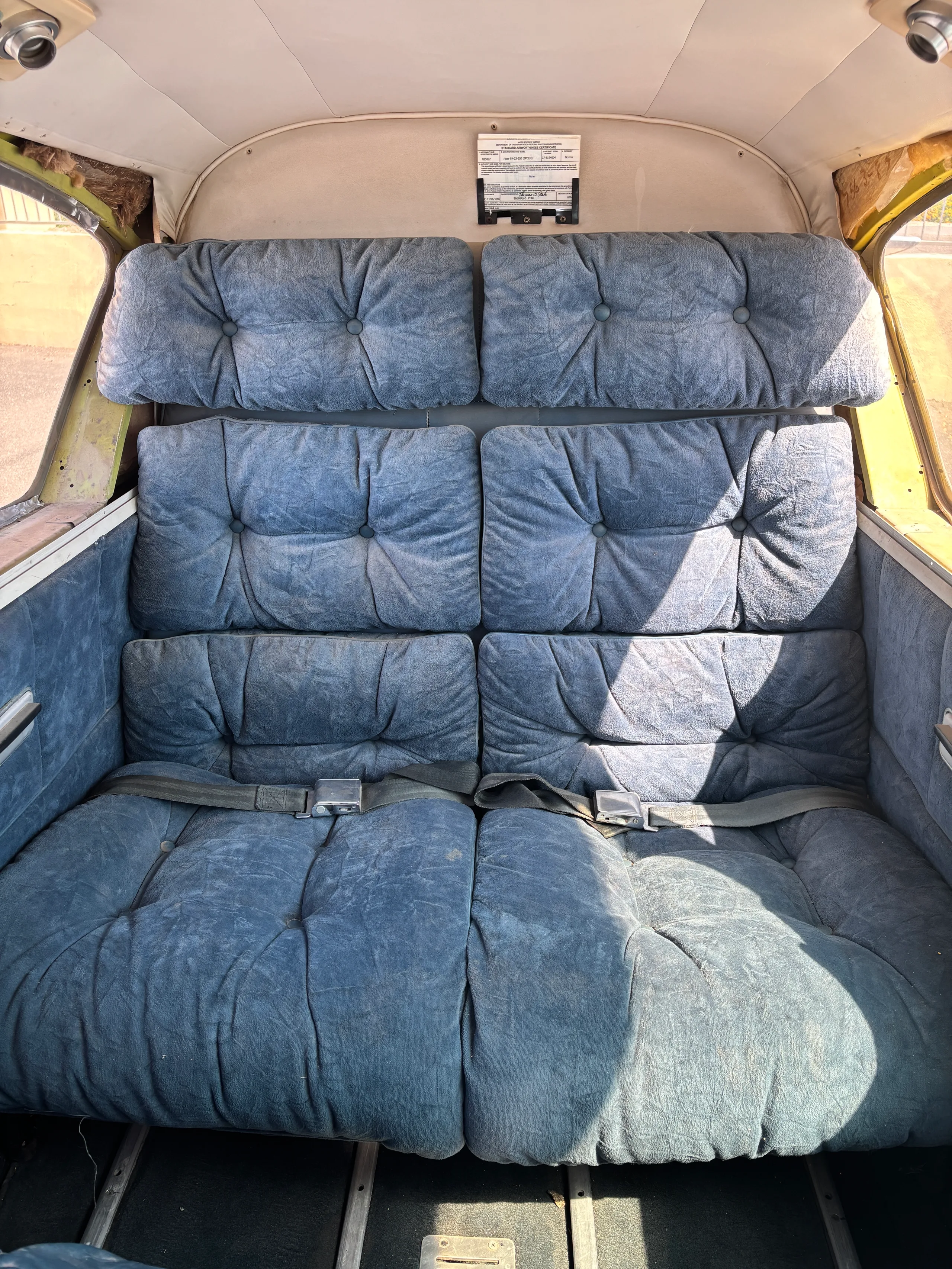 View of the aircraft's worn blue plush rear cabin seats.