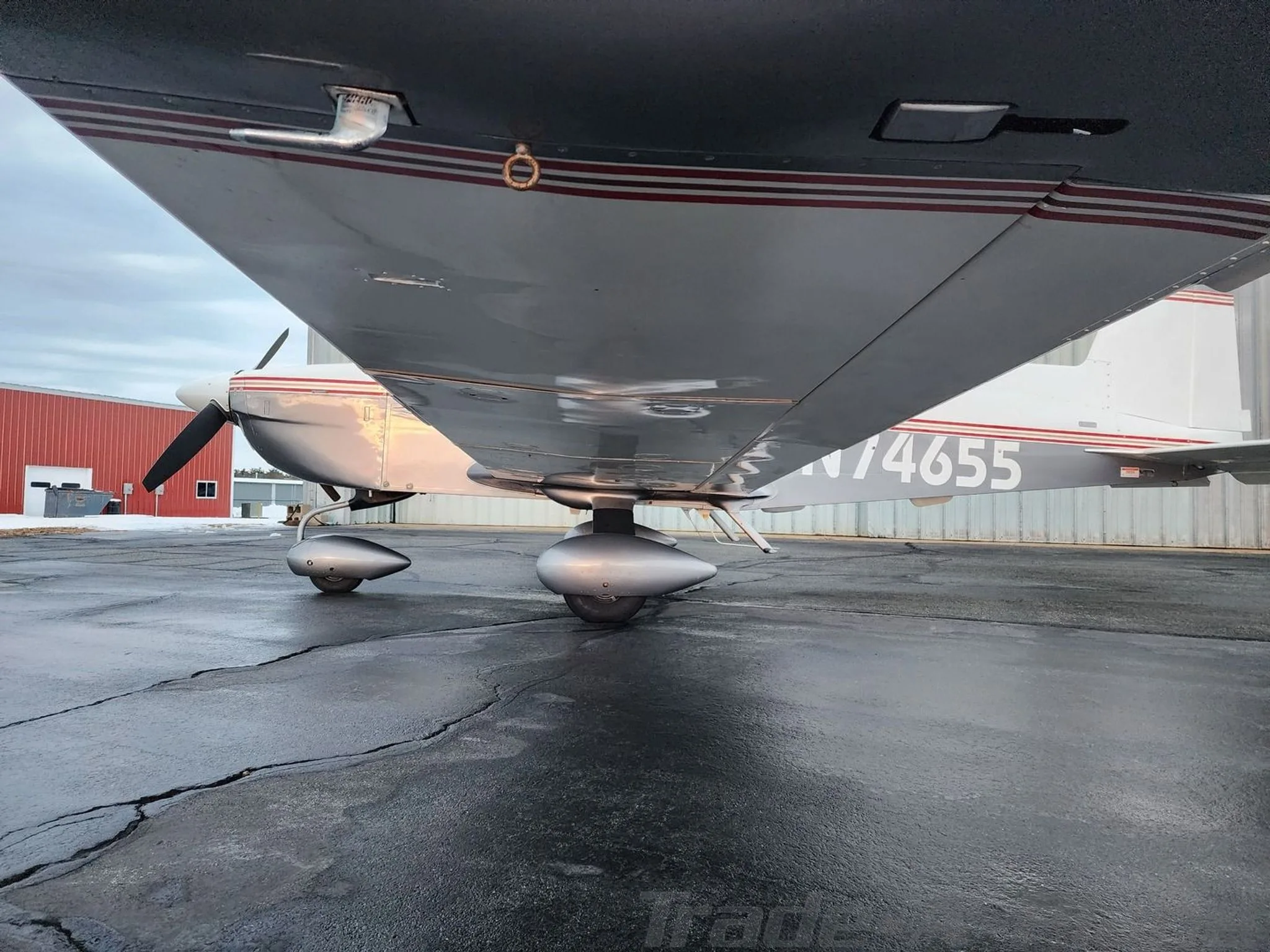 An underwing view of the Grumman American aircraft, N74655, showing the landing gear and the underside of the wing.