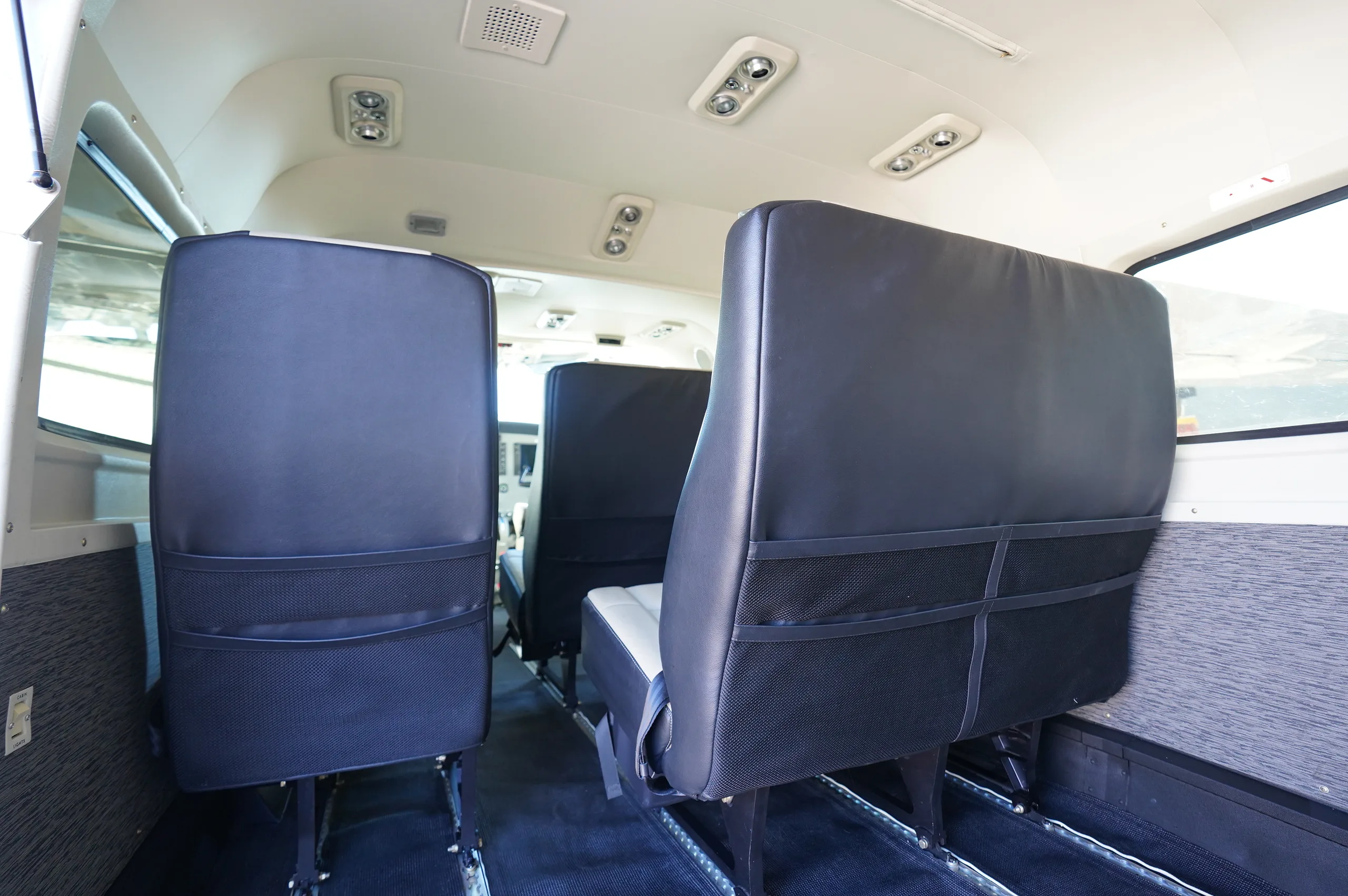 The rear cabin interior of the aircraft showing two rows of black passenger seats.