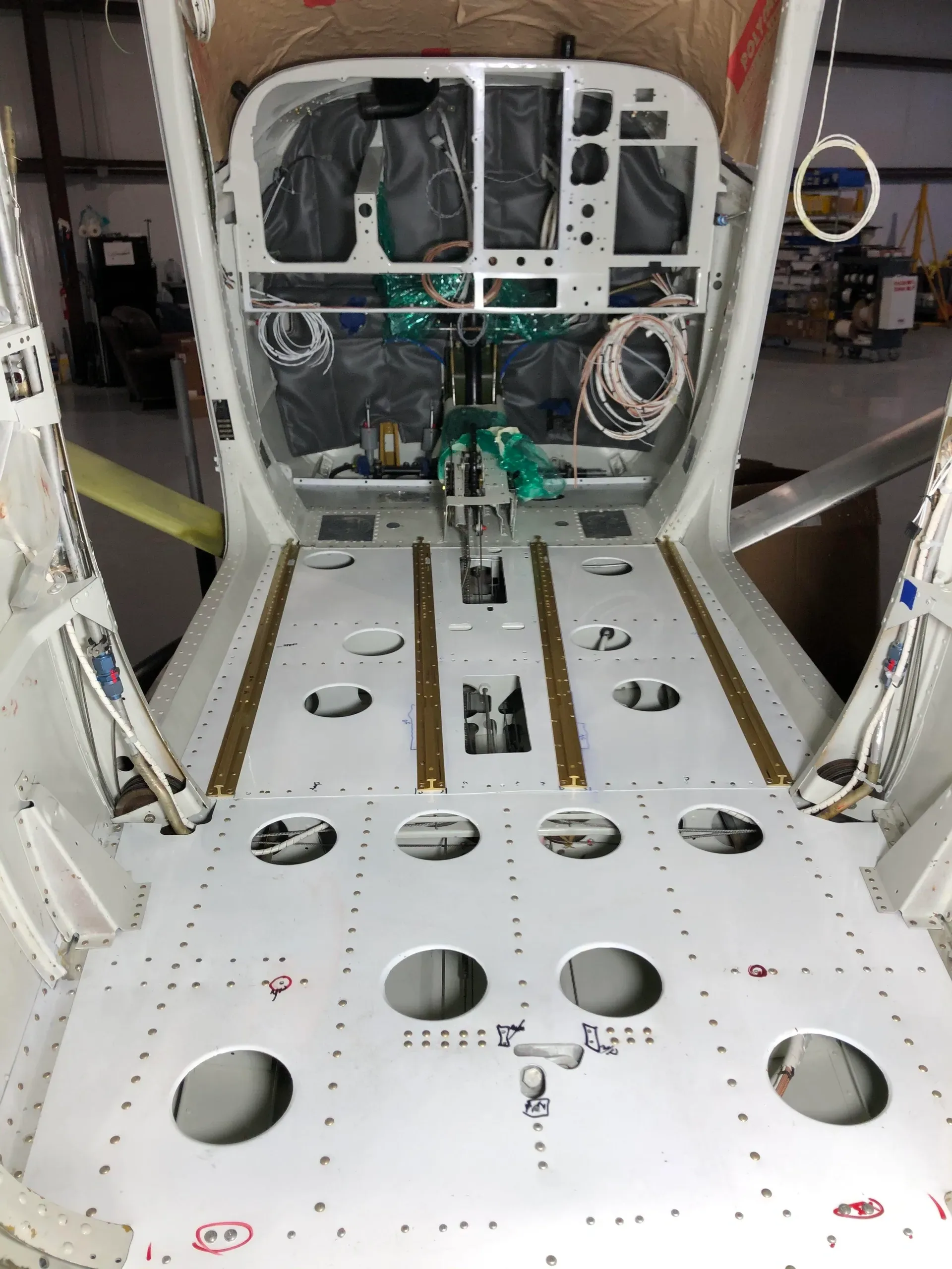 An overhead view of the aircraft's internal fuselage structure during assembly, showing floor panels and wiring.