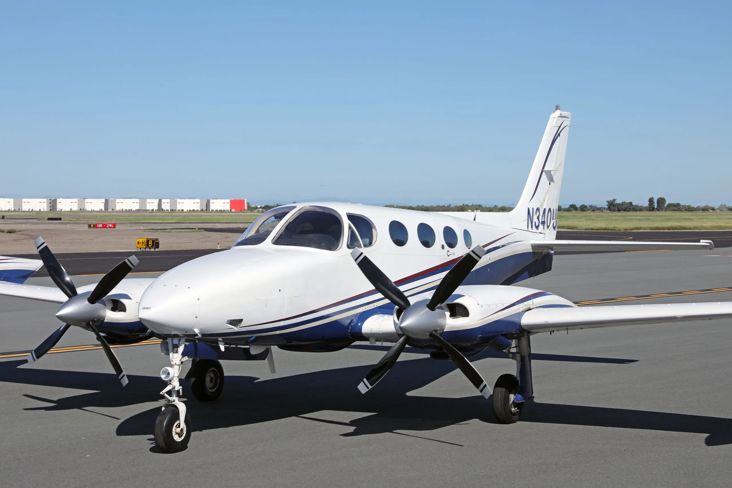 A close-up front view of a white and blue Cessna 340 twin-engine aircraft with registration N340U on an airfield.