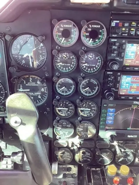 A detailed view of the aircraft's instrument panel, featuring multiple analog gauges for torque, temperature, and speed, alongside digital displays.