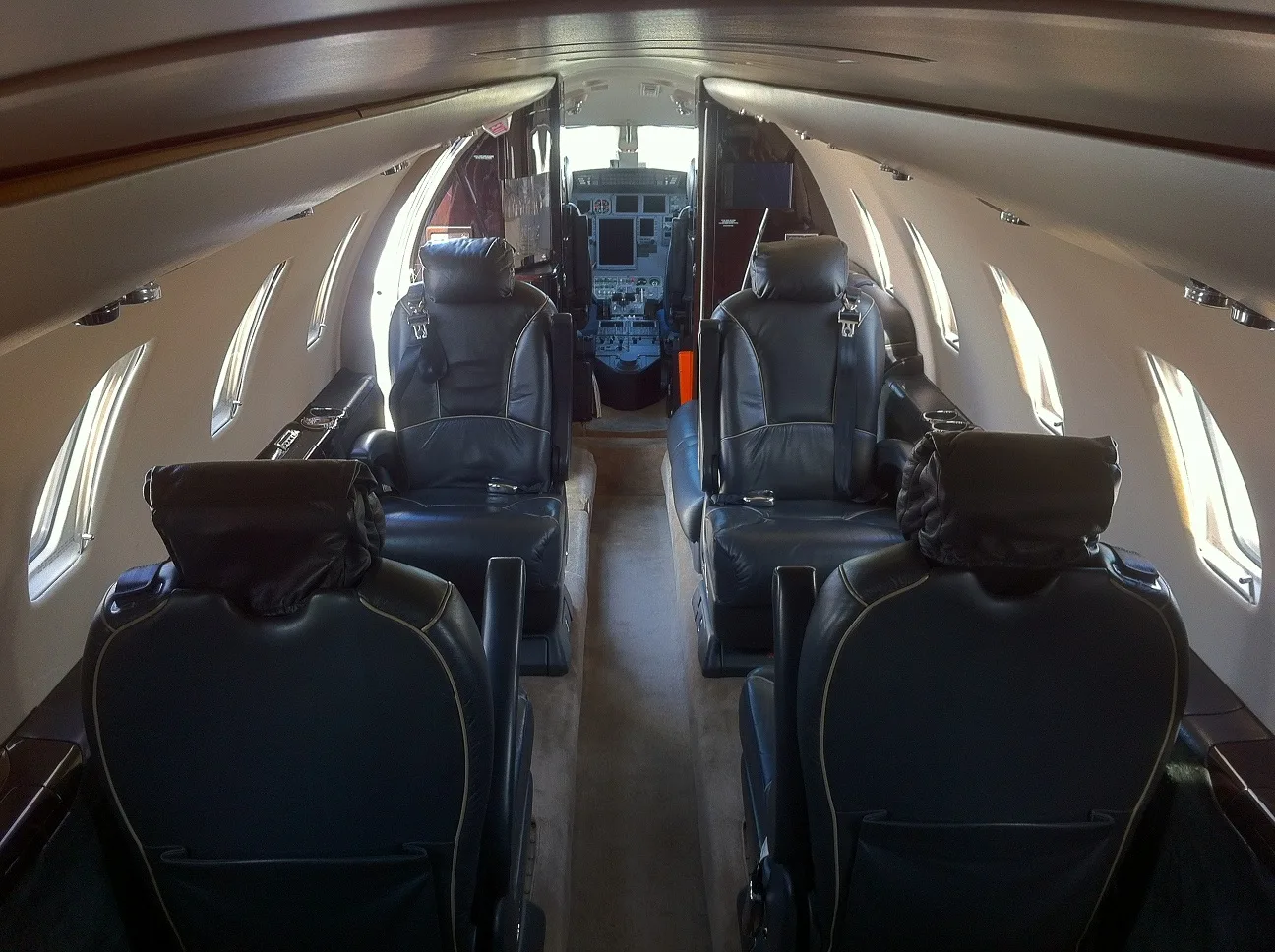 Cabin view with leather seats and cockpit in the background.
