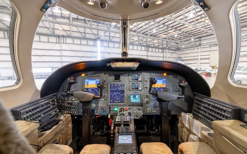 The cockpit of a Cessna Citation CJ3 with multiple display screens and controls, viewed from the pilot's seat.