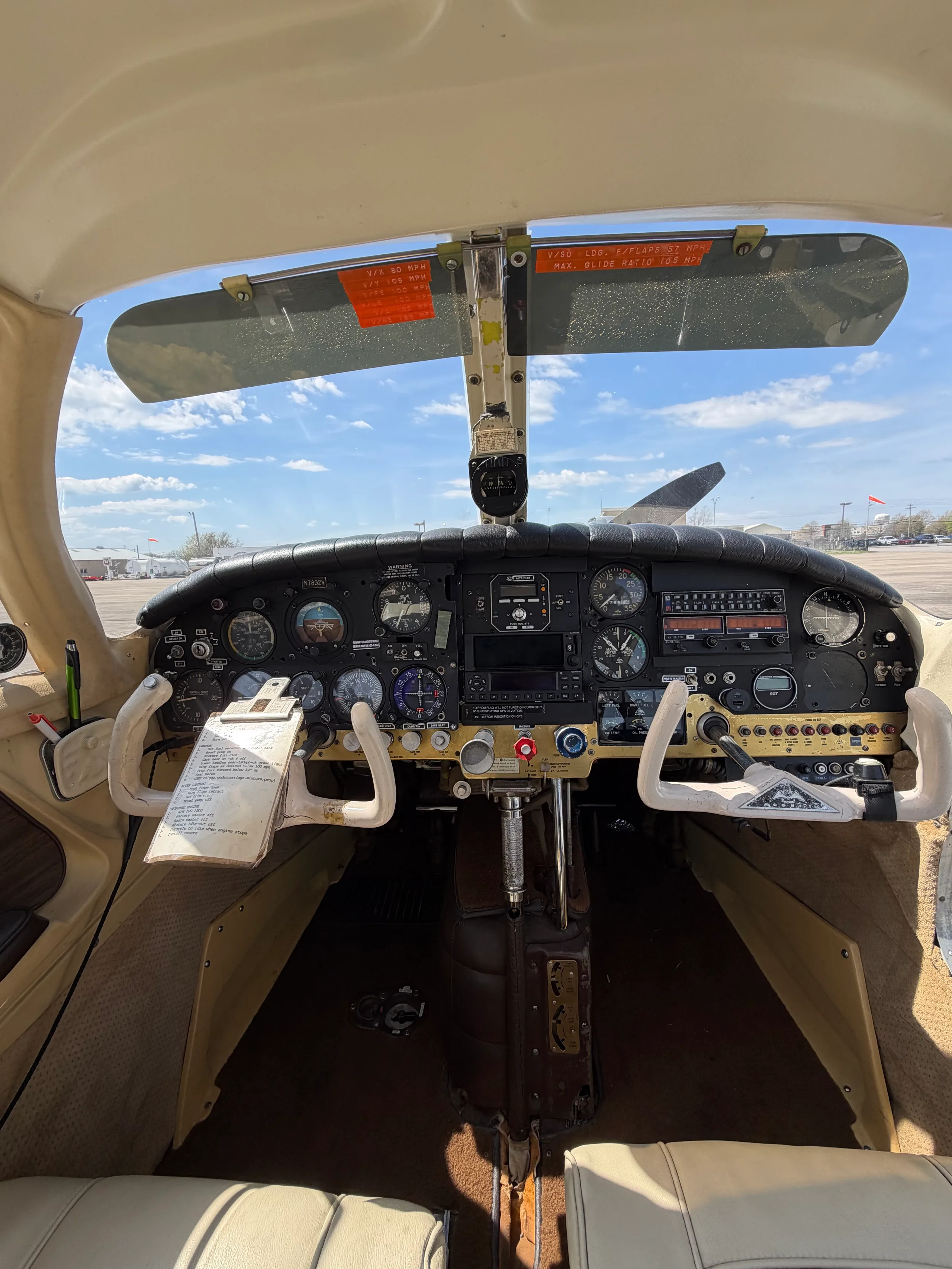 The cockpit of a small aircraft, showing the instrument panel, yokes, and controls.