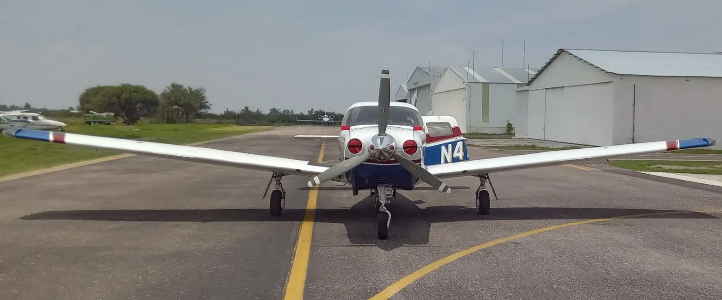 Front view of a Piper Saratoga II TC aircraft with white and blue paint scheme on a tarmac.
