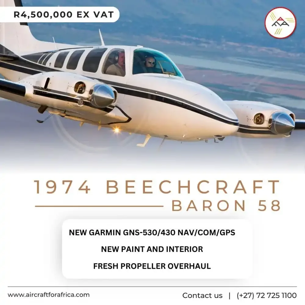 A white Beechcraft Baron 58 with black stripes flies against a mountainous background.