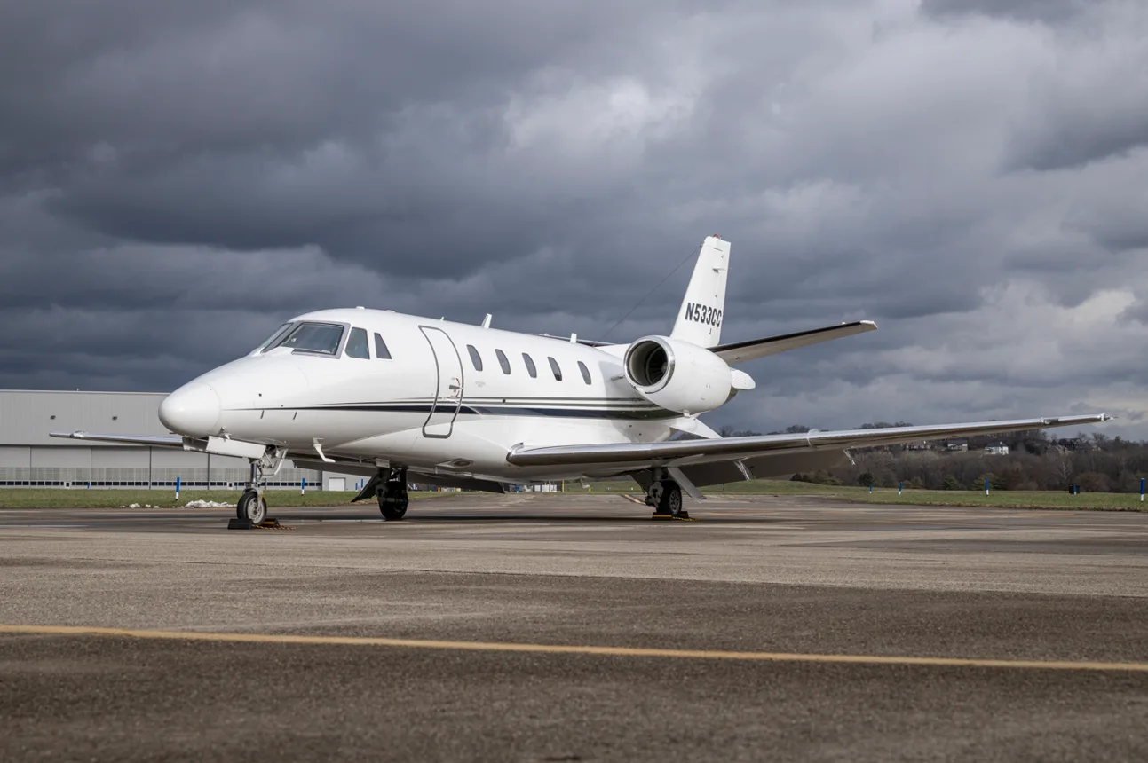 A white Cessna Citation business jet with tail number N533CC parked on an airport tarmac under a cloudy sky.