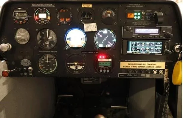 The instrument panel of an aircraft, featuring various gauges, radios, and controls.