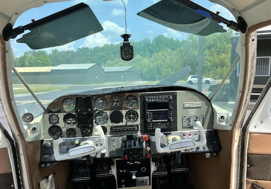 Full view of the Beechcraft Sundowner 180 cockpit with dual yokes and a comprehensive instrument panel.