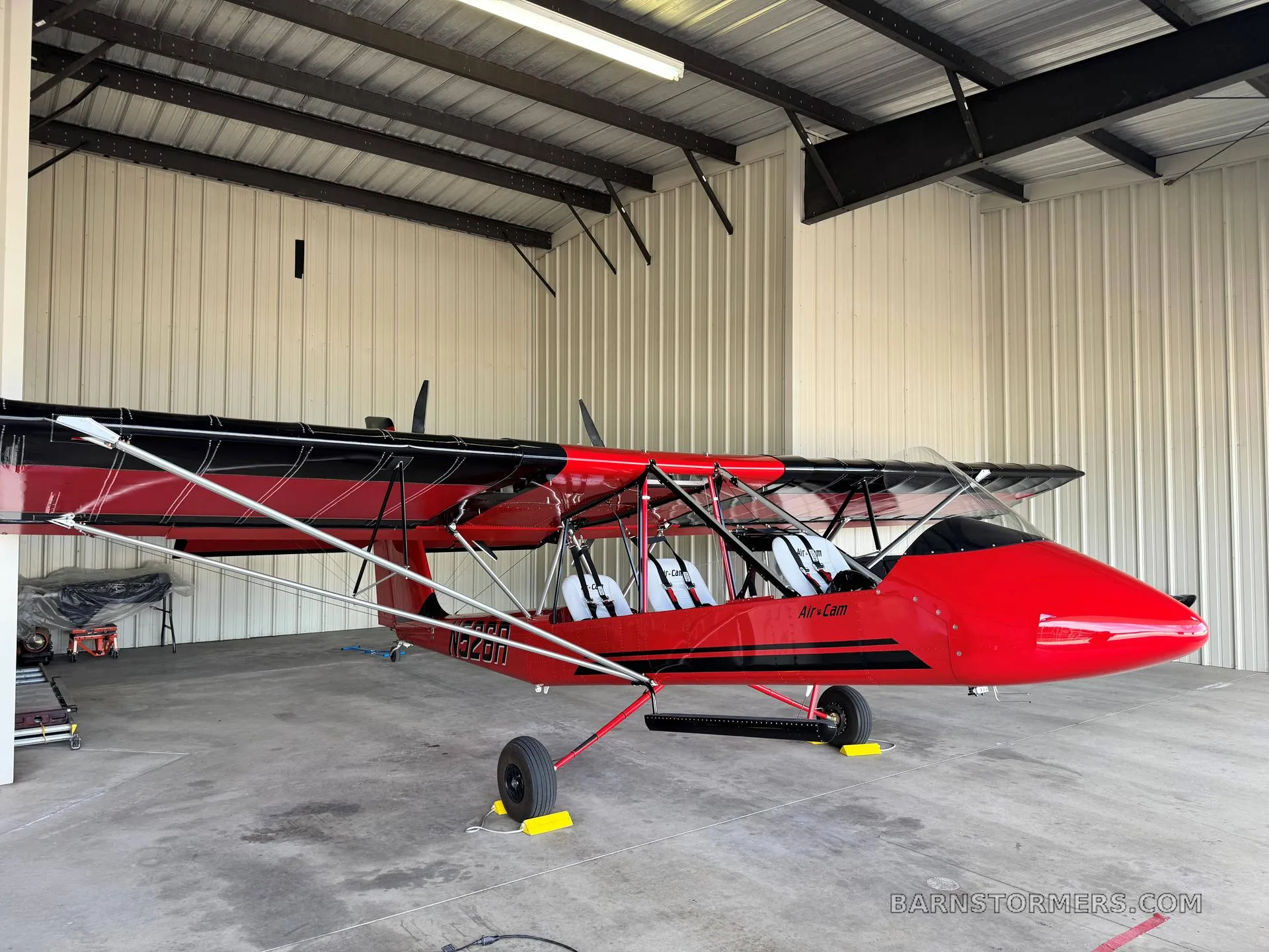A red and black Air-Cam aircraft with registration N1349U is parked inside a hangar.