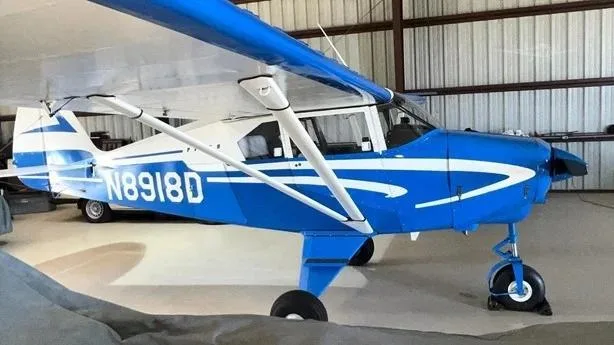 A blue and white single-engine aircraft, N8918D, parked in a hangar.