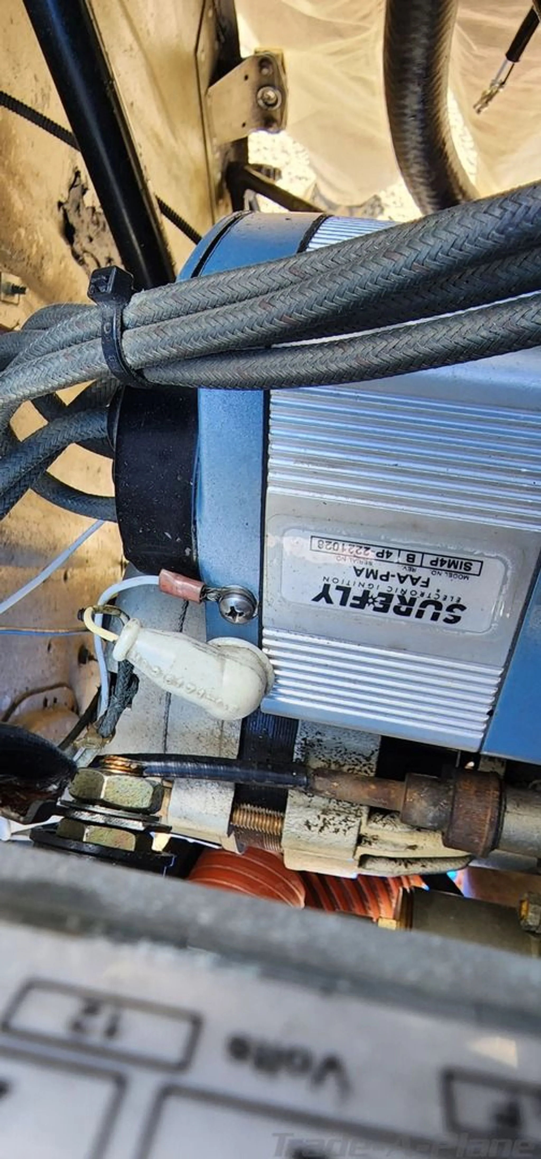 A close-up view of an aircraft engine component labeled "SUREFLY FAA-PMA" with wires and connections.