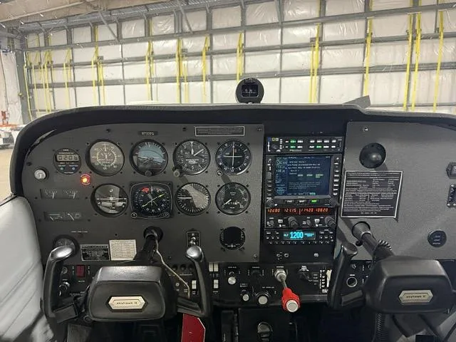 The instrument panel of a Cessna 172 Skyhawk, featuring analog gauges and a digital avionics display.