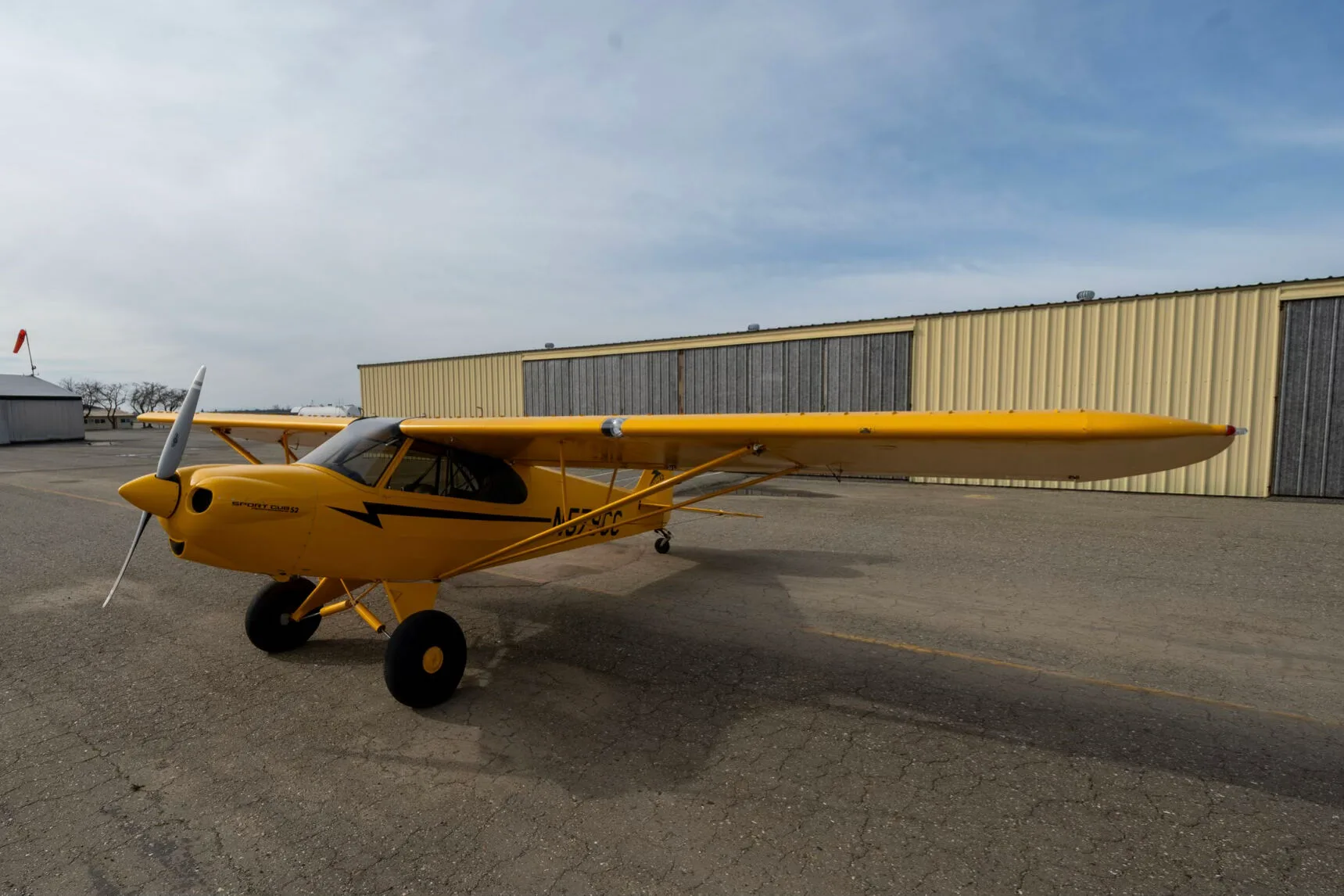 A front-left view of the yellow CubCrafters Sport Cub S2 aircraft N579CC parked on an airfield.