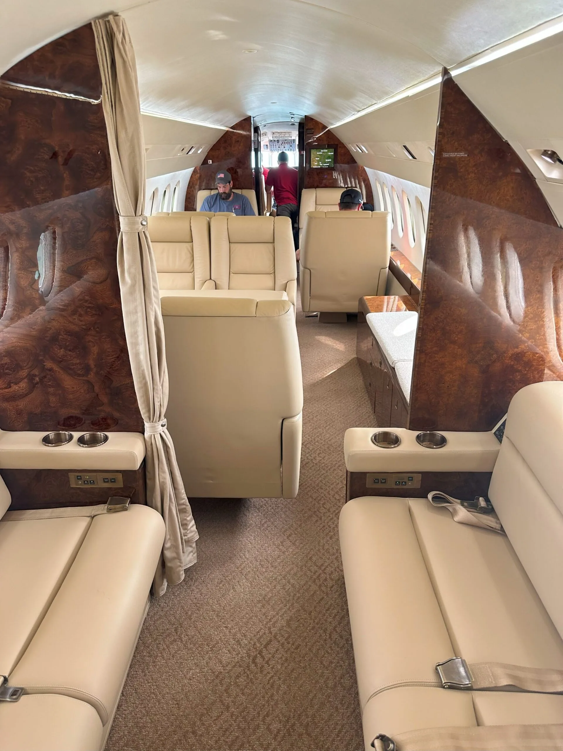 View down the aisle of the aircraft cabin with leather seats.