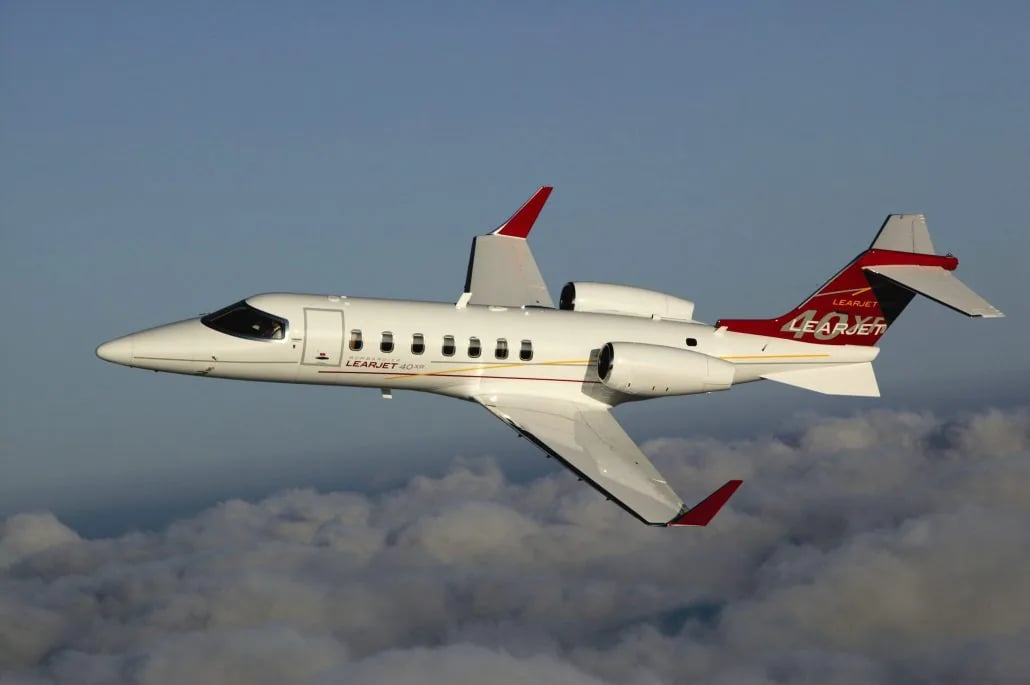 A Learjet 40XR is flying above the clouds.