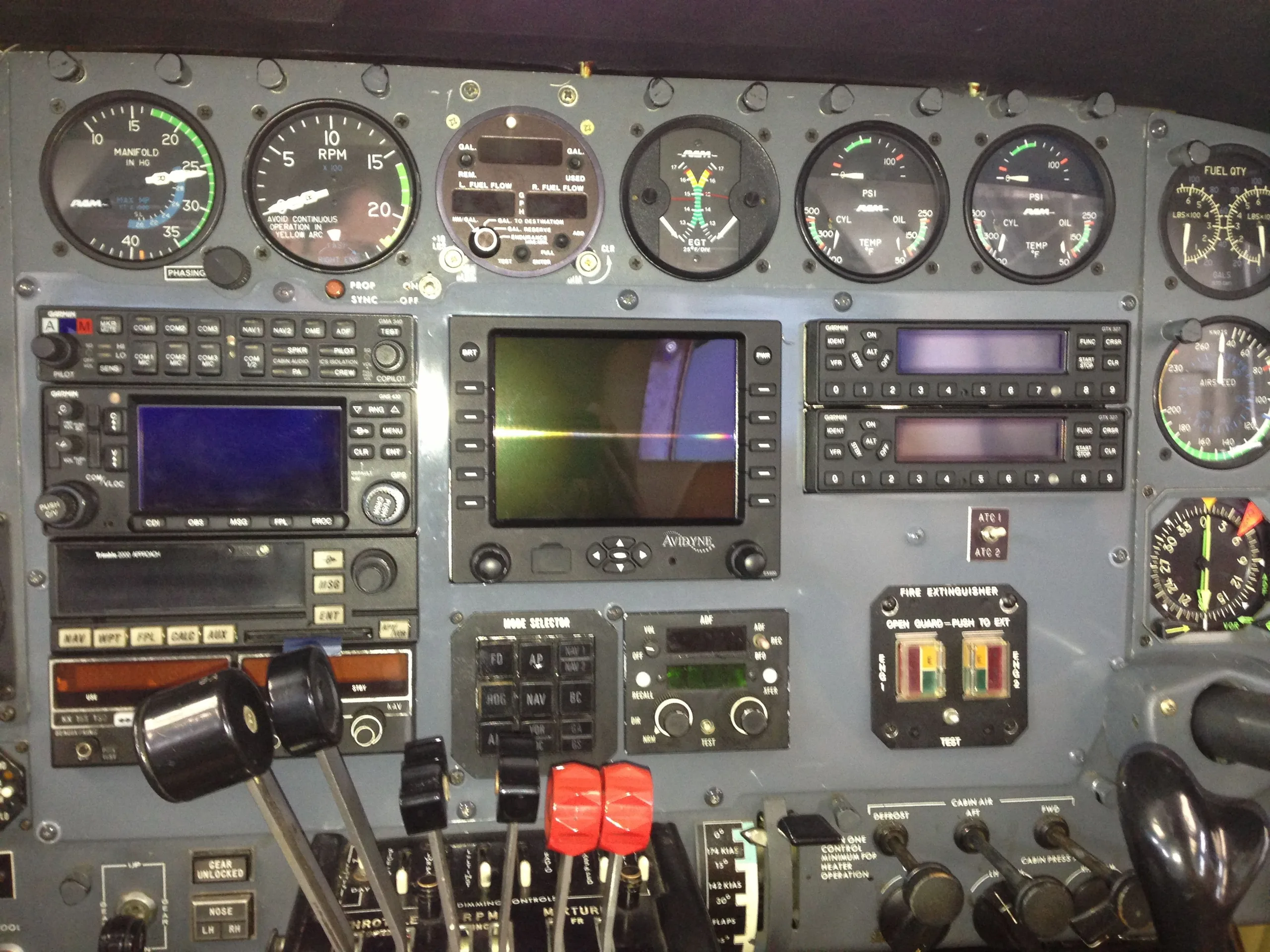 A detailed close-up view of an aircraft's instrument panel, showing various gauges, avionics, and controls.
