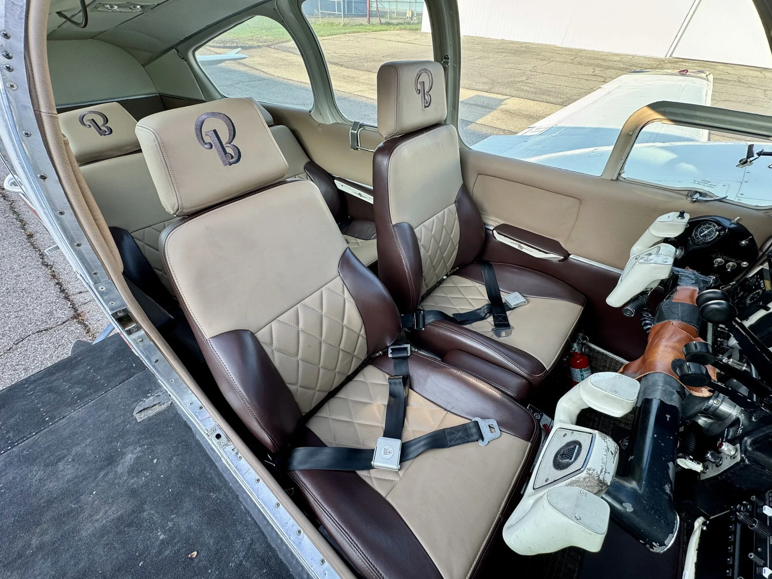 View of the front seats in the Beechcraft Baron B55 cabin, featuring brown and tan leather upholstery.